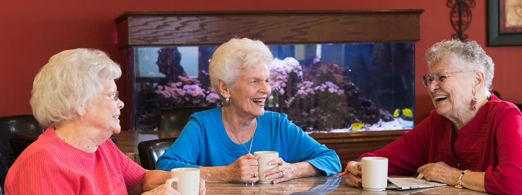 Three women - residents of the Mt. Creek are sitting at a coffee table and having a good time